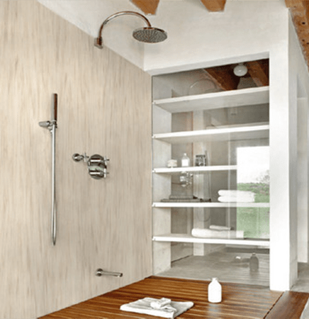 Modern shower design featuring a wall-mounted showerhead, sleek chrome fixtures, and a glass storage shelf showcasing towels and toiletries.